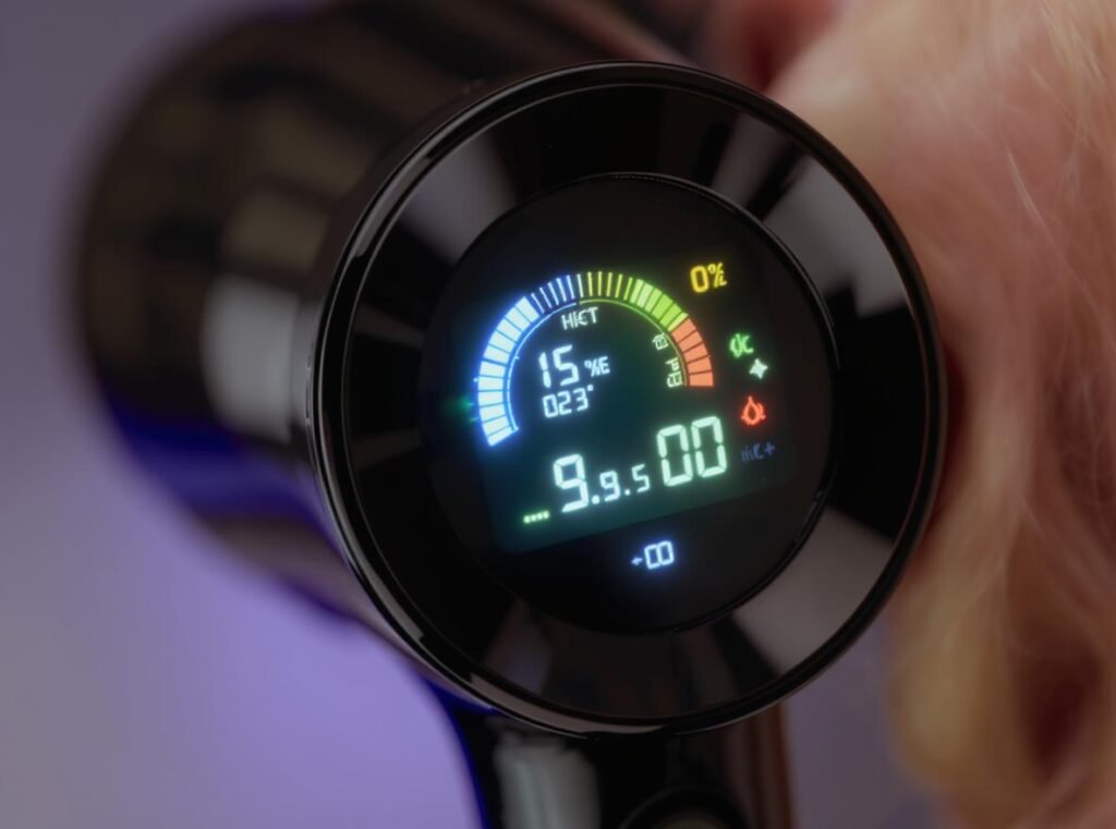 Close-up of hair dryer LED display showing color-coded temperature settings